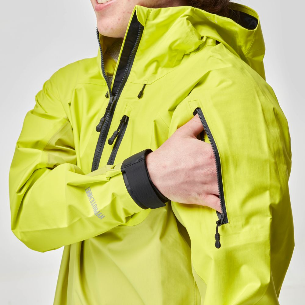 A man adjusts the sleeve zipper of his bright yellow NRS High Tide Jacket.