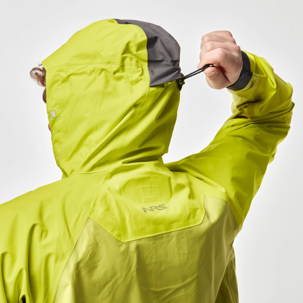 A person adjusts the hood of the NRS High Tide Jacket in bright green, featuring a dark gray visor, viewed from the back.