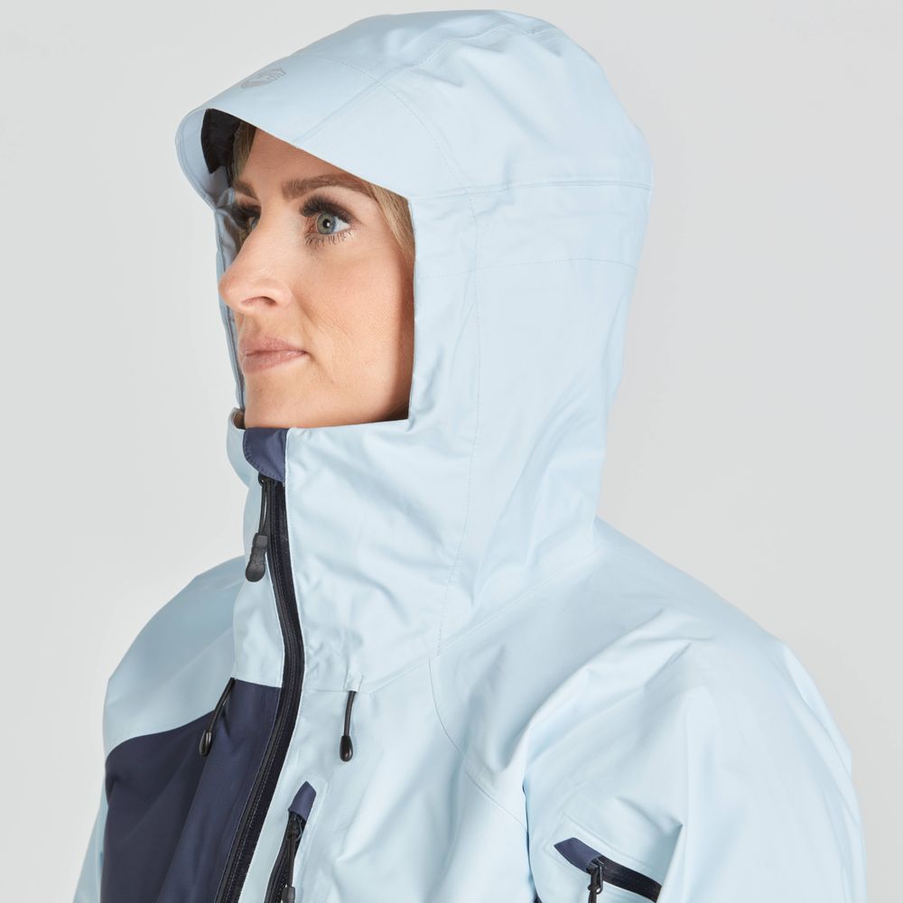 A person wearing the light blue NRS High Tide Jacket - Women's, featuring a paddler's cut for flexibility, looks to the side against a plain background.