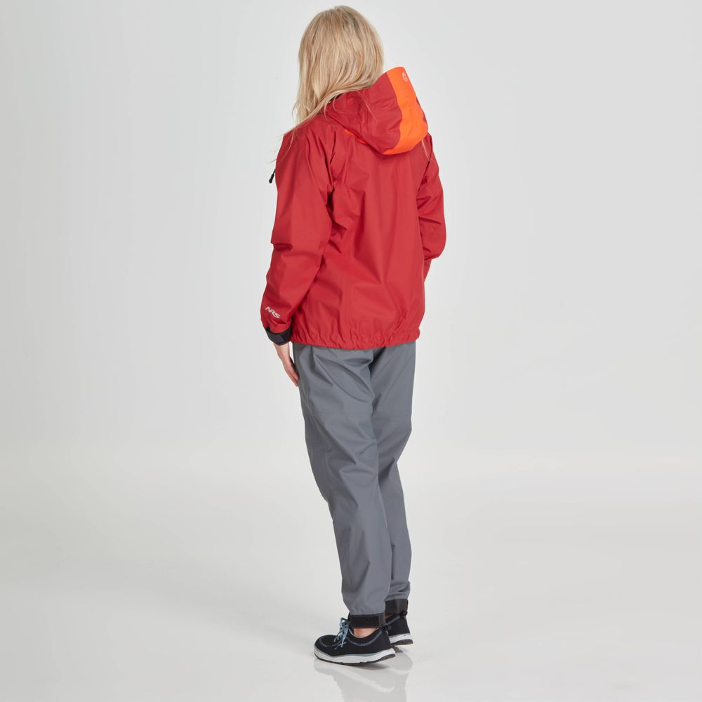 A person with long blonde hair is facing away, wearing the NRS High Tide Jacket - Women's in red with an orange hood, along with gray pants.