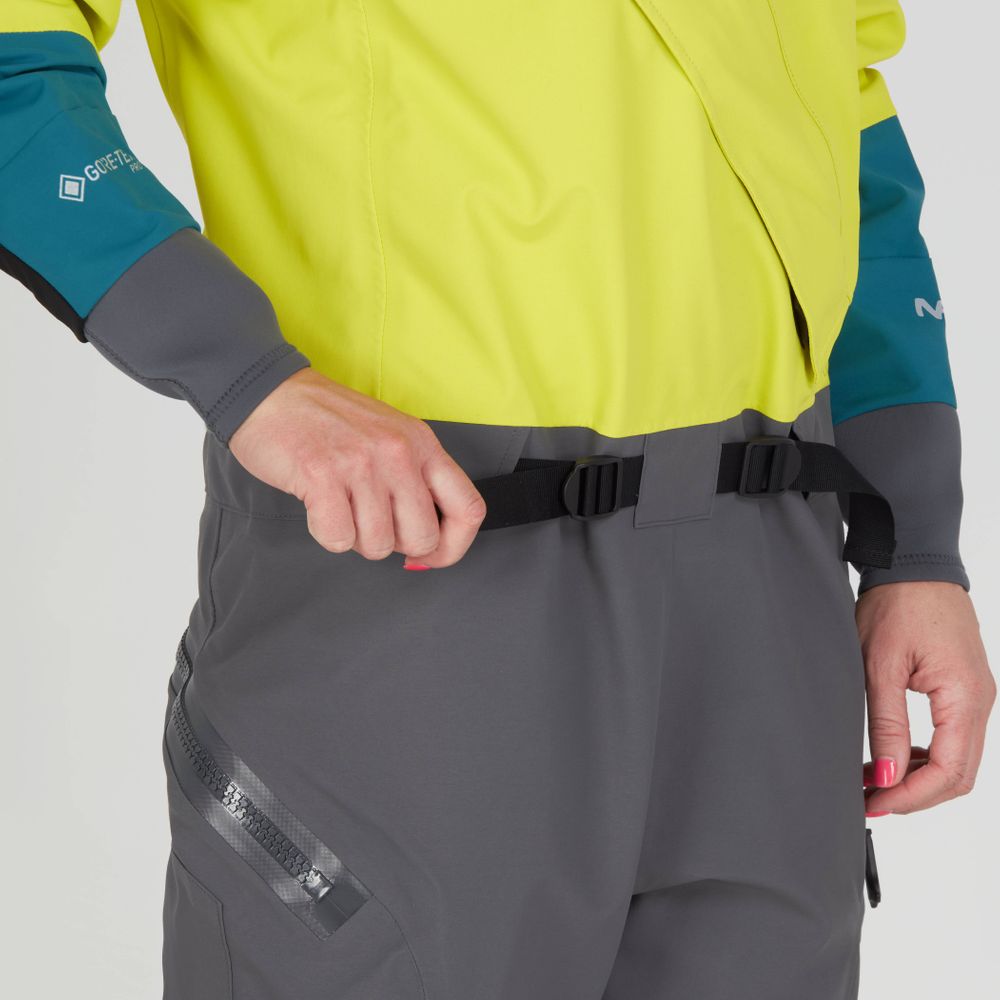Wearing the NRS Nomad GORE-TEX Pro Semi-Dry Suit in yellow and gray, she adjusts a black belt for ideal waterproof performance.