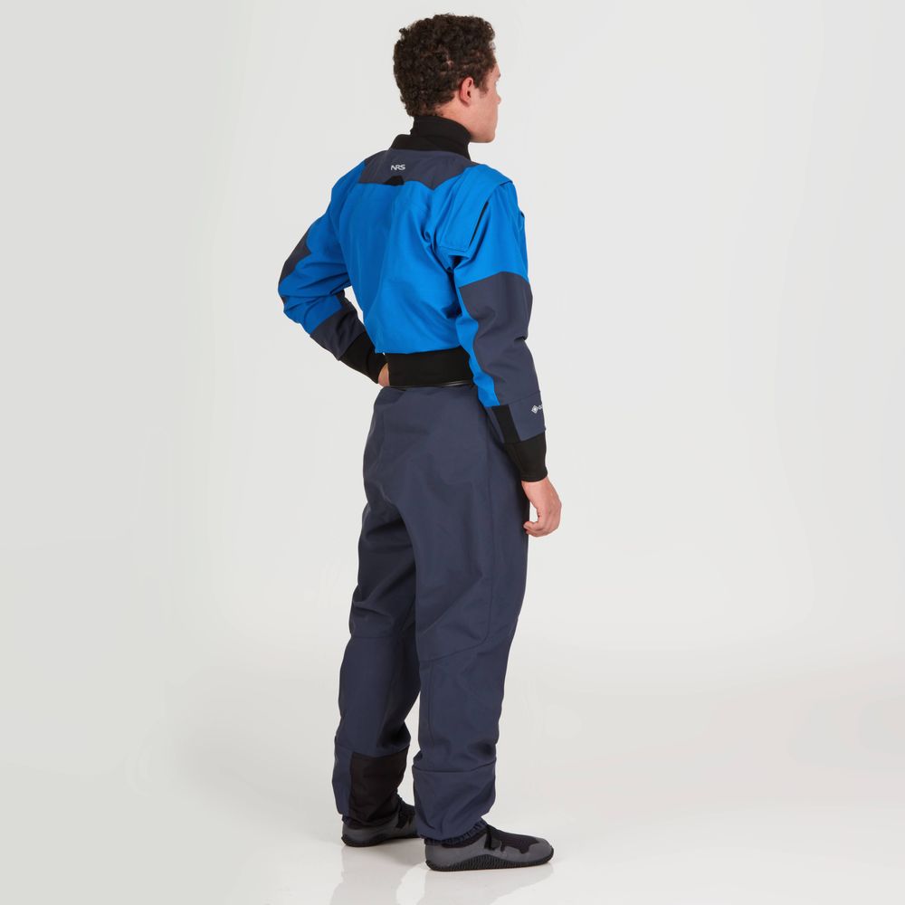 Clad in the NRS Axiom (GORE-TEX Pro) Drysuit, crafted from recycled nylon, and paired with gray boots, a person confidently stands with hands on hips. They face away from the camera, ready for any adventure in waterproof, windproof, breathable gear.
