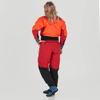 The individual in a vibrant orange and red Axiom GORE-TEX Pro Drysuit by NRS, featuring black accents, stands poised against a neutral backdrop, showcasing its waterproof, windproof, and breathable design.