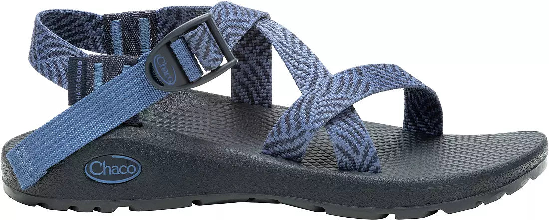 A blue Chaco ZCloud - Women's sandal with adjustable straps, a black textured sole with Cloud Cushioning, a ChacoGrip rubber outsole, and a side buckle is shown against a white background.