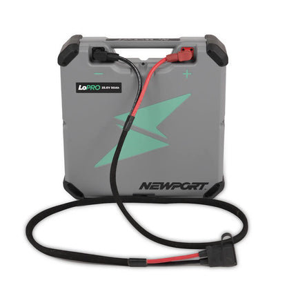 The Newport LoPro 25.6V 50Ah lithium boat battery is lightweight and portable, featuring a convenient carrying handle, a green lightning bolt design, and attached black and red cables for seamless energy solutions on the go.