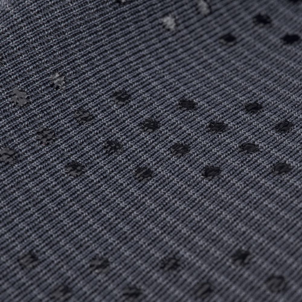 Close-up of a gray ribbed fabric with scattered black dots, similar to the neoprene core in NRS Hydroskin 0.5mm Gloves - Women's, ideal for cold water paddling.