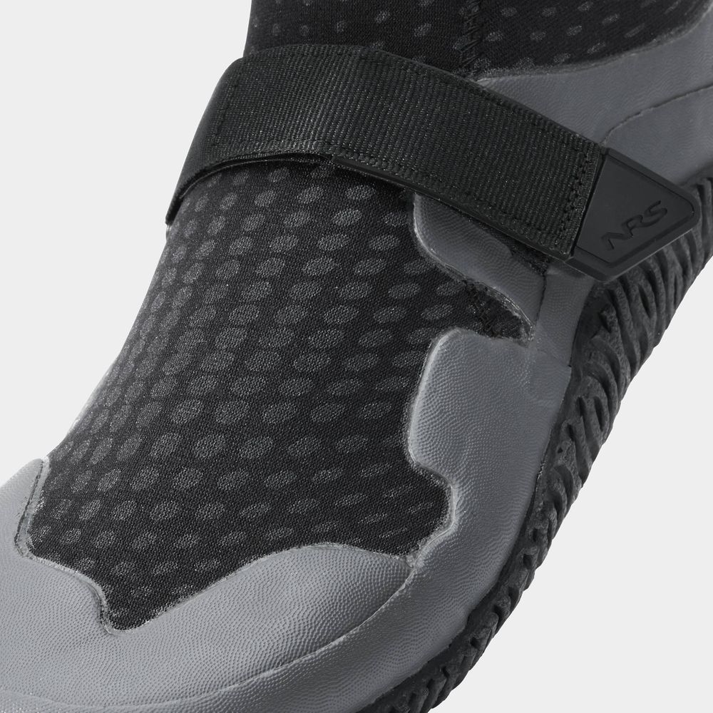 Close-up of the NRS Paddle WetShoe, a black and gray water shoe with Velcro strap, showcasing textured neoprene for durability and a high-traction sole for better grip.
