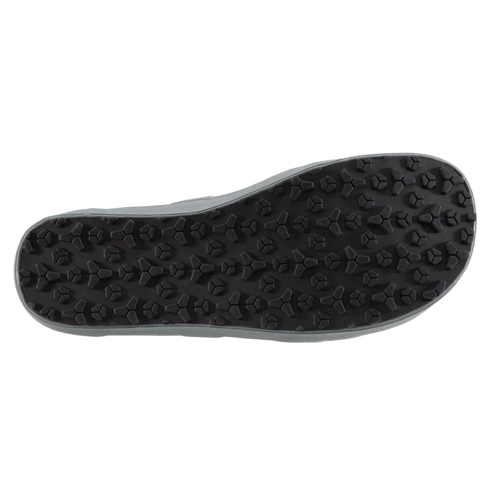 The image displays the sole of the NRS Backwater Wetshoe, featuring hexagonal studs for traction. Ideal for kayakers and anglers, the black sole is shown from a bottom view, emphasizing its grip-enhancing design suitable for wet environments.