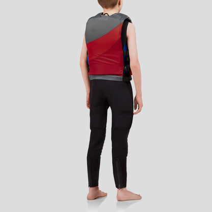 A person stands barefoot in a red and gray NRS Crew Youth PFD life jacket with US Coast Guard Type III Certification, wearing a black wetsuit. They are set against a plain gray backdrop, facing away from the camera.