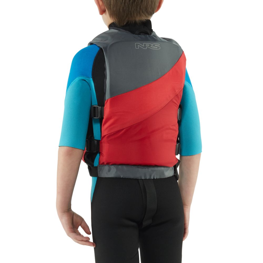A child, clad in a blue wetsuit, wears a red and gray NRS Crew Child PFD (US Coast Guard-certified), standing with their back to the camera.