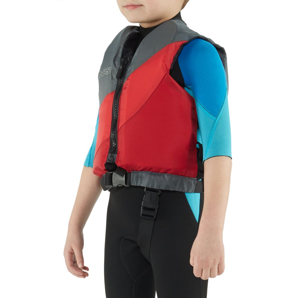 A child wearing an NRS Crew Child PFD, a US Coast Guard Certified red and grey life jacket, stands confidently against a plain white background in a blue wetsuit.