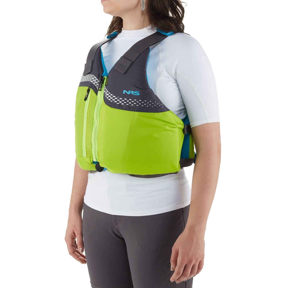 A person is seen from the side wearing a bright green NRS Vista PFD, U.S. Coast Guard certified life jacket, over a white top and gray pants.