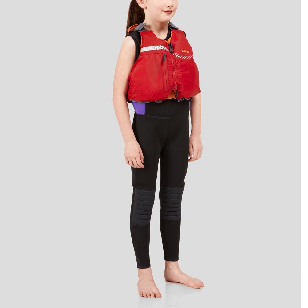 A young child, barefoot against a gray backdrop, wears NRS's Vista Youth PFD—a stylish red life jacket made of durable 400 denier nylon—paired with black pants. The Type III flotation device ensures safety and comfort.
