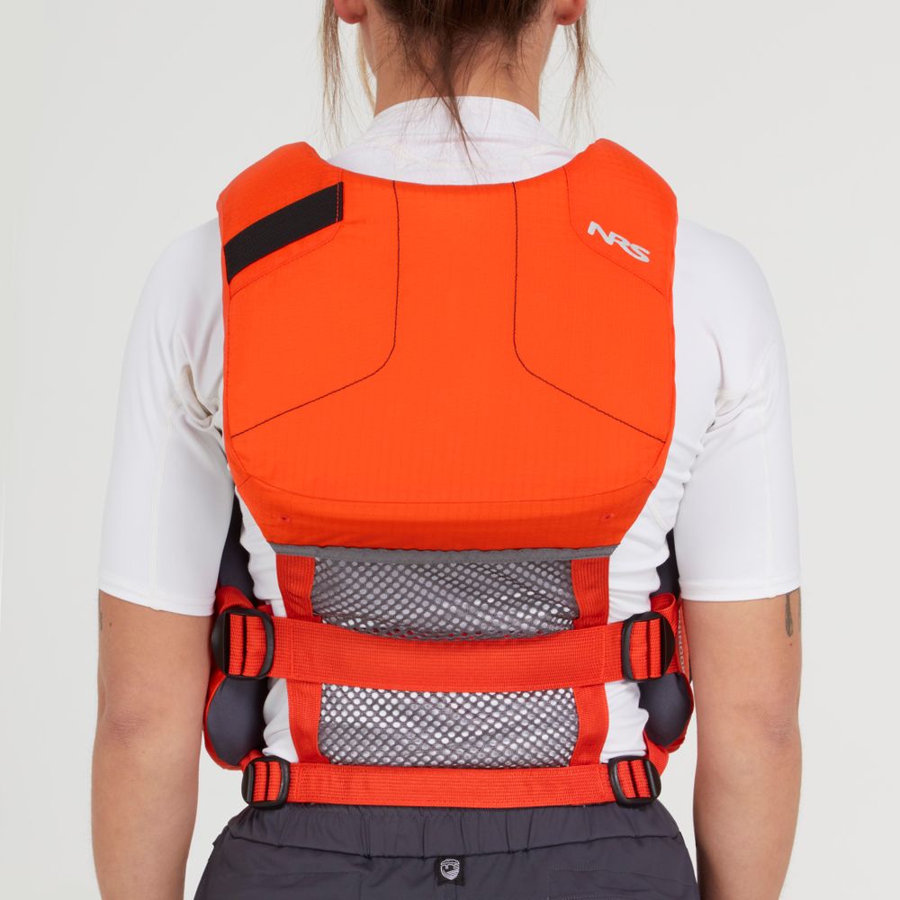 An individual is wearing an NRS Chinook Fishing PFD, with its vibrant red fabric standing out against the white shirt underneath in a back view.