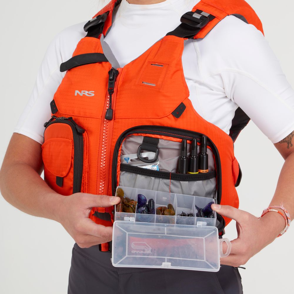 A person wearing an NRS Chinook Fishing PFD, featuring handy gear attachment points, holds a tackle box filled with fishing accessories visible from the front pocket.