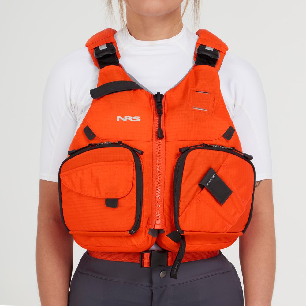 A person is wearing an NRS Chinook Fishing PFD over a white shirt, showcasing an orange design with black straps, pockets, and practical gear attachment points.