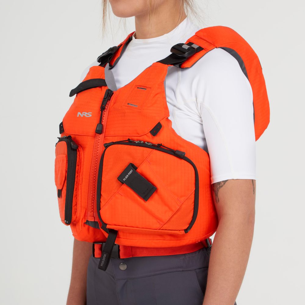 Dressed in a vibrant Chinook Fishing PFD by NRS over a white shirt and dark pants, the person stands sideways, prepared for any adventure.