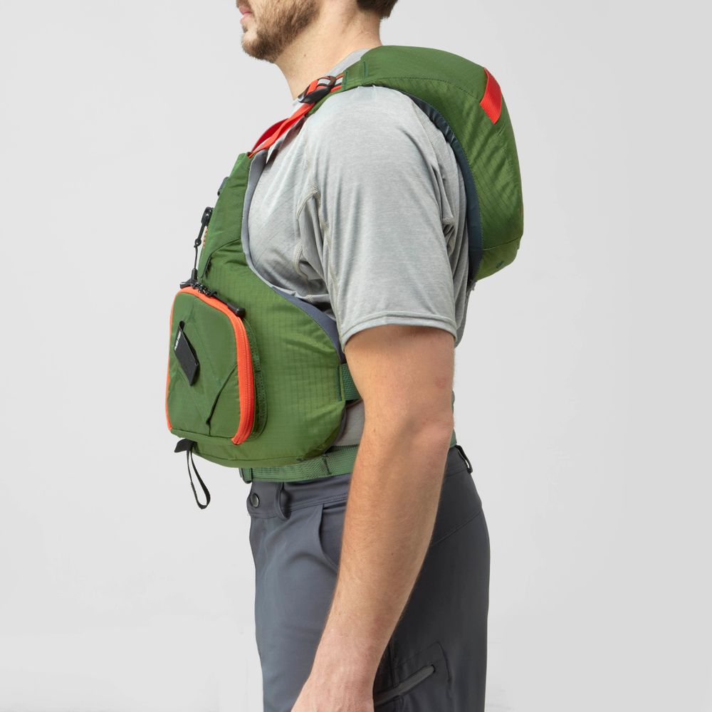 A man in a gray shirt and dark pants models the NRS Chinook Fishing PFD, shown in green and orange from the side against a plain background.