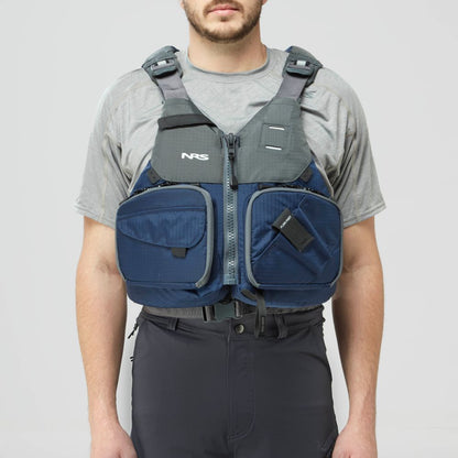 A man in a gray t-shirt and black pants models the NRS Chinook Fishing PFD, a blue and gray life jacket with multiple front pockets, against a plain background.