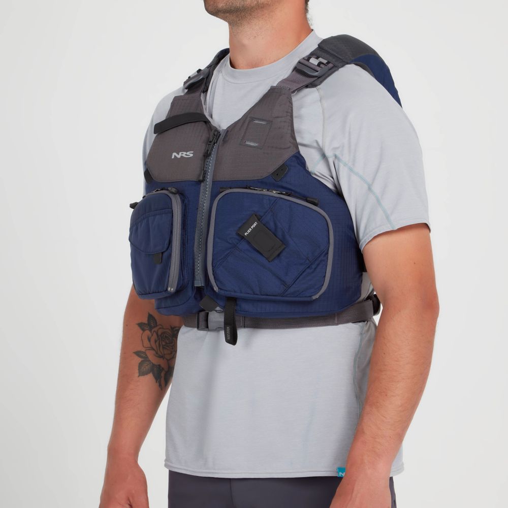 A person is seen from the side, wearing an NRS Chinook Fishing PFD in blue and gray over a light gray shirt, featuring gear attachment points.