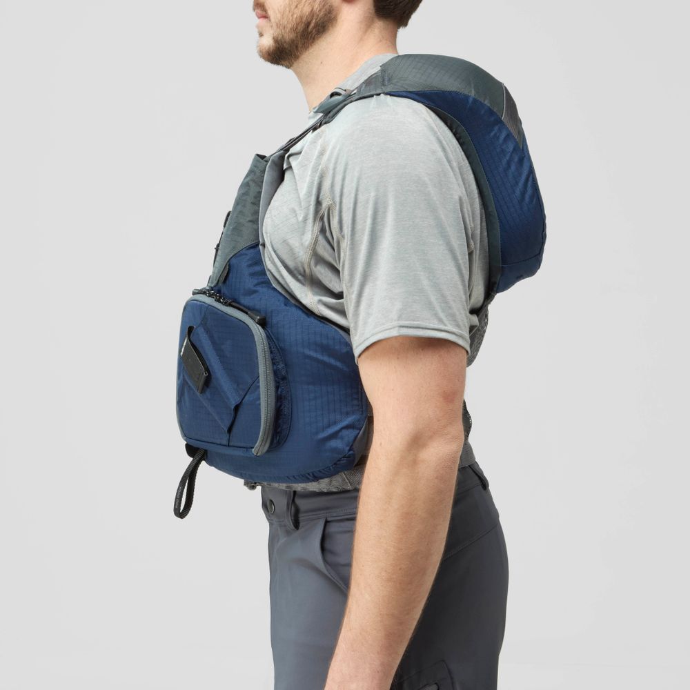 A man in a grey t-shirt and pants is shown from the side wearing the NRS Chinook Fishing PFD in blue and grey.