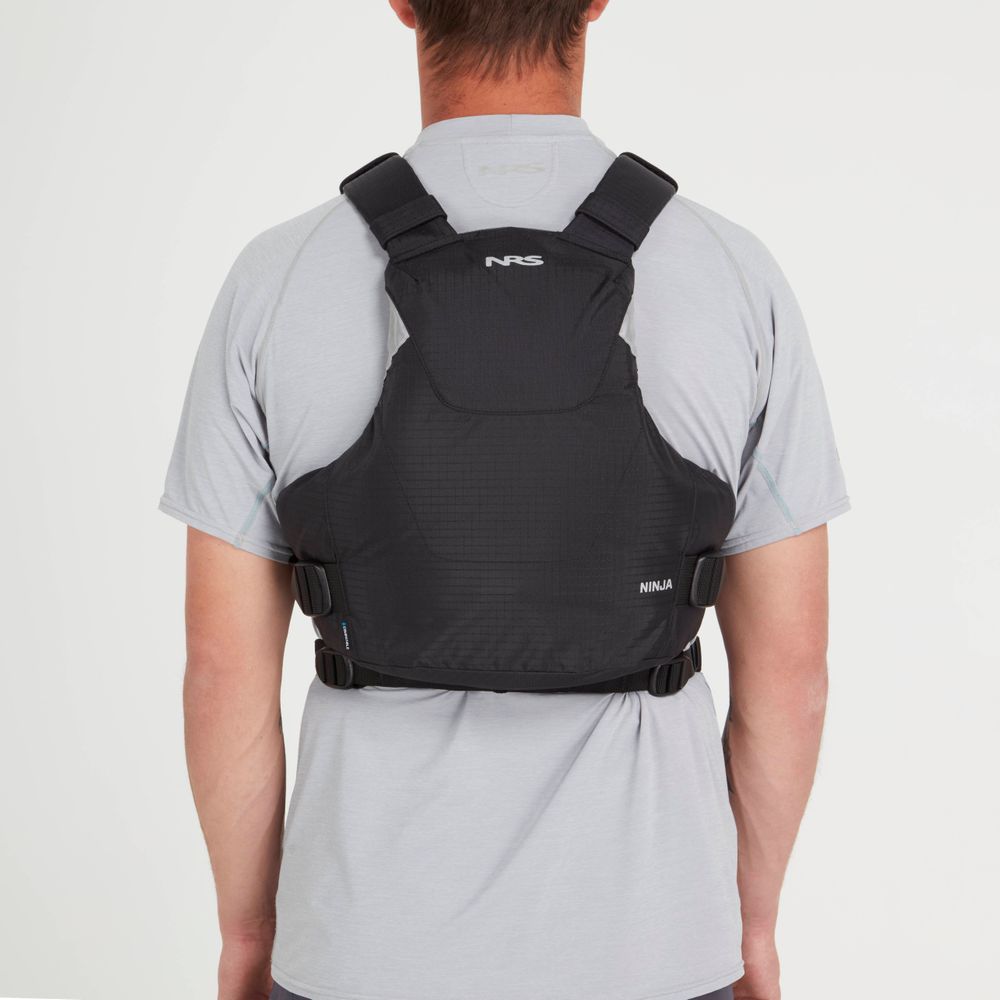 Seen from the back, a person dons a black NRS Ninja PFD over a gray T-shirt, showcasing its sleek design and comfort similar to an orbit fit system.