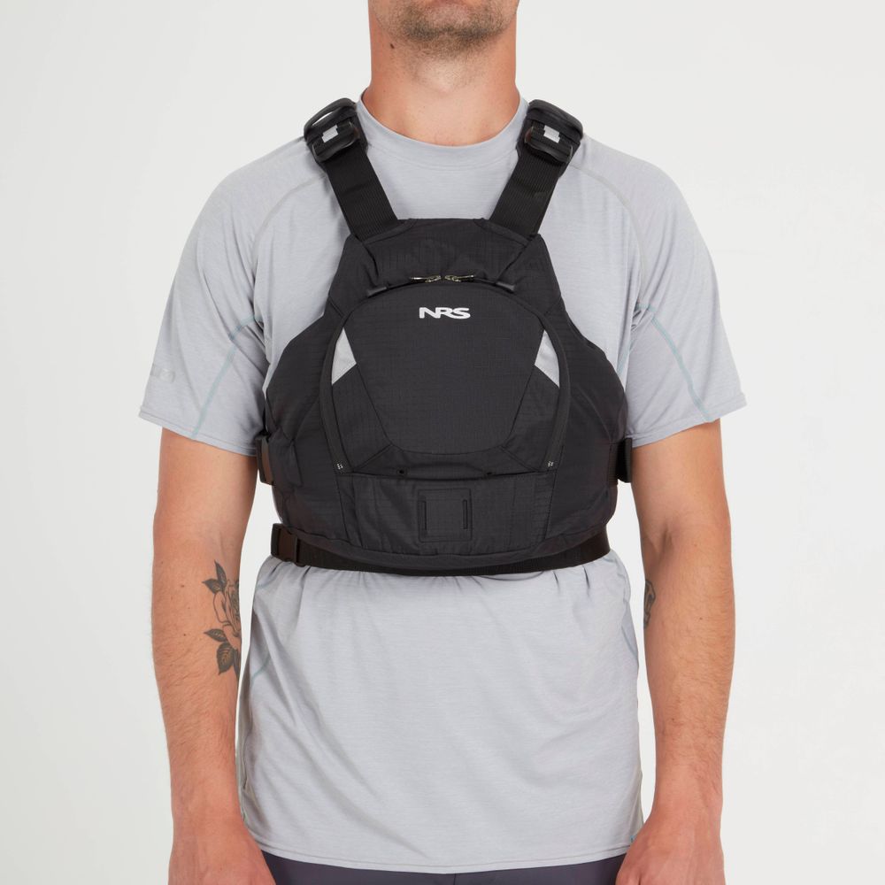 A person stands against a plain backdrop wearing an NRS Ninja PFD over a gray t-shirt.