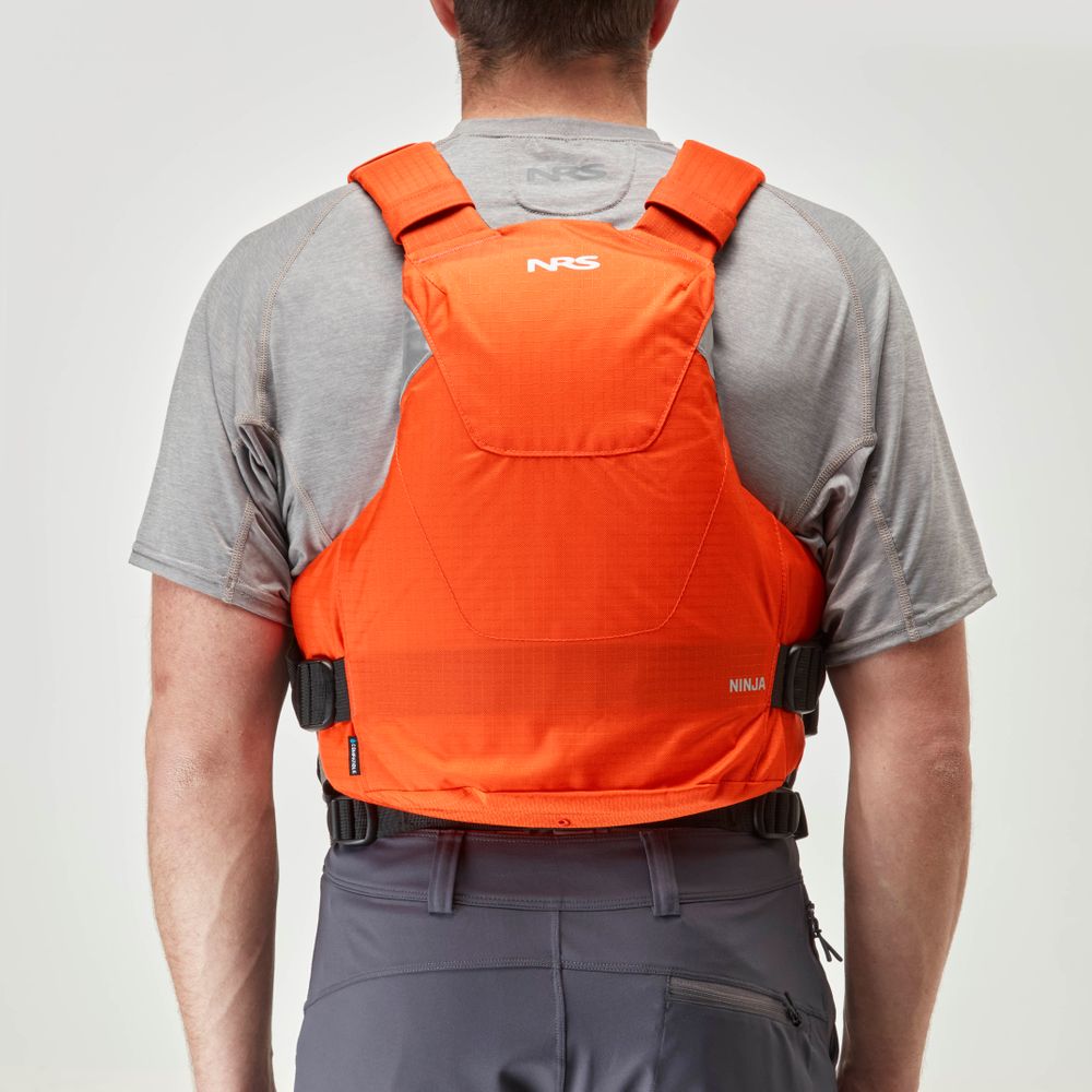 A person is wearing a gray shirt and an orange NRS Ninja PFD with "NRS" on the back.