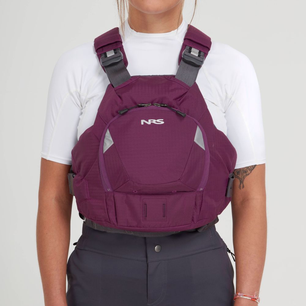 Someone wearing an NRS maroon Ninja PFD over a white top and dark pants, standing against a plain background.