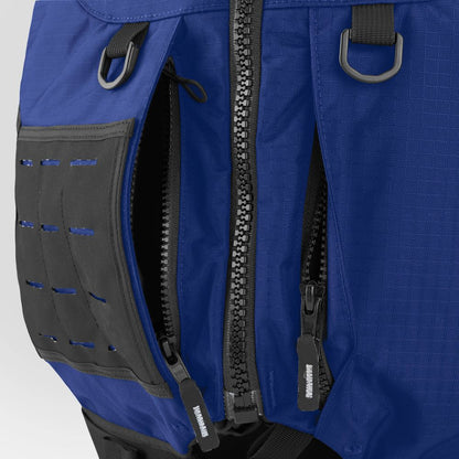 Close-up of an NRS Big Water Guide Hi-Float backpack in blue, featuring black zippers, webbing loops, and a front panel with horizontal slots—perfect for carrying your type III life jacket or other boating safety essentials.