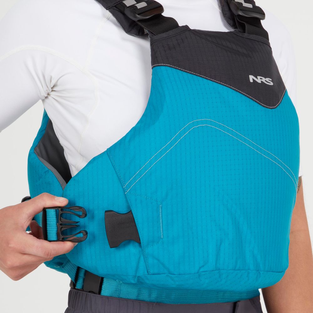 Someone wearing an NRS Vapor PFD life jacket adjusts the side straps, with a white long-sleeve shirt underneath—ideal for paddling excursions.