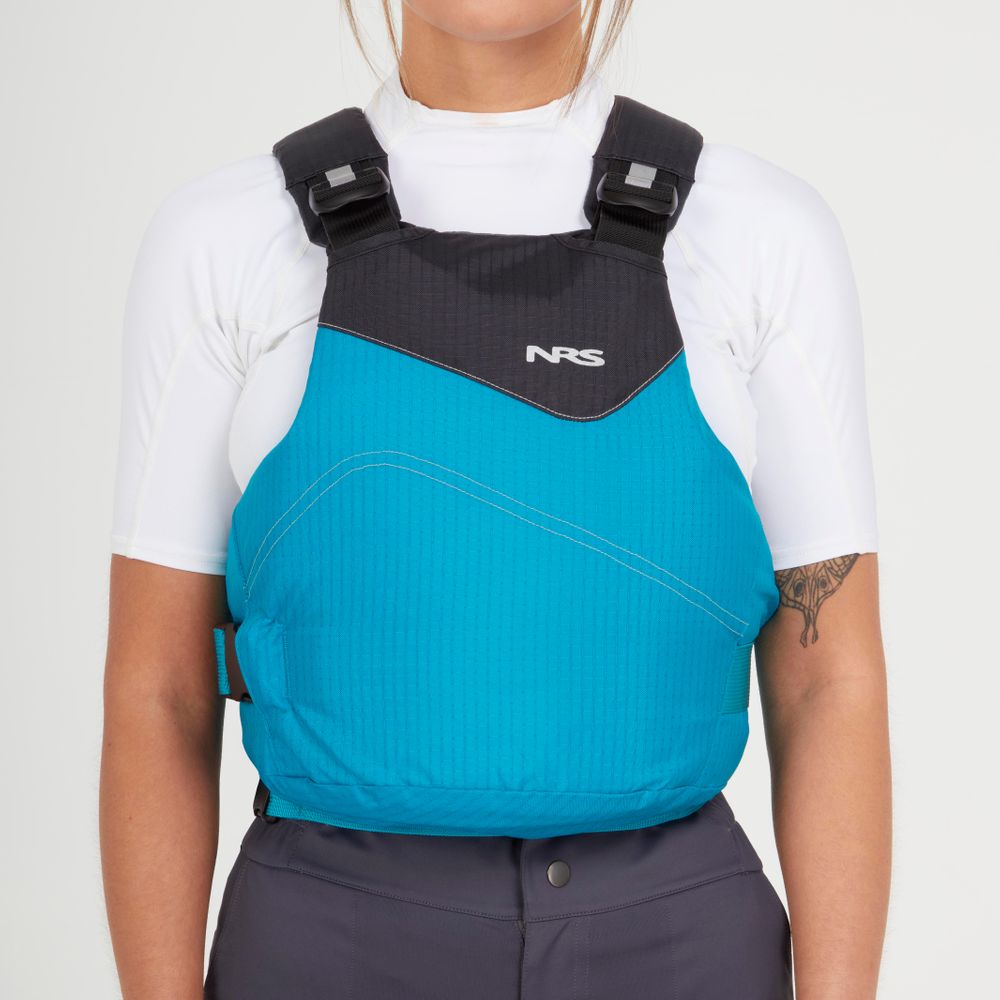 A person wears an NRS Vapor PFD life jacket over a white shirt, showing a tattoo on their upper left arm.