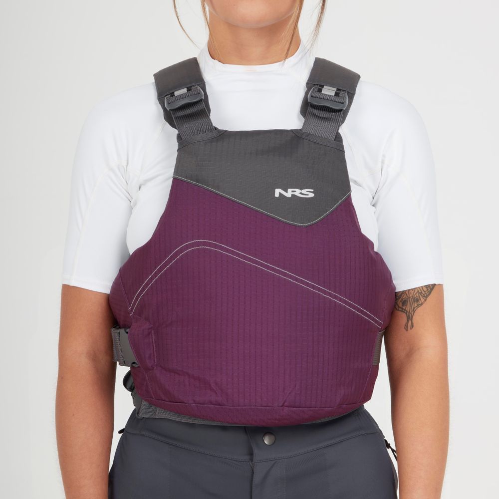 A person wearing an NRS Vapor PFD in purple and gray over a white shirt, shown from shoulders to waist against a plain background—ideal gear for paddling with comfort and safety.