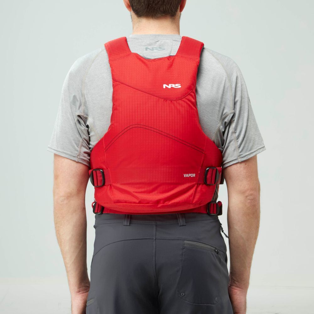 A person in a grey shirt and dark shorts, seen from behind, wears the NRS Vapor PFD life jacket in red—securely fastened and ideal for paddling adventures.