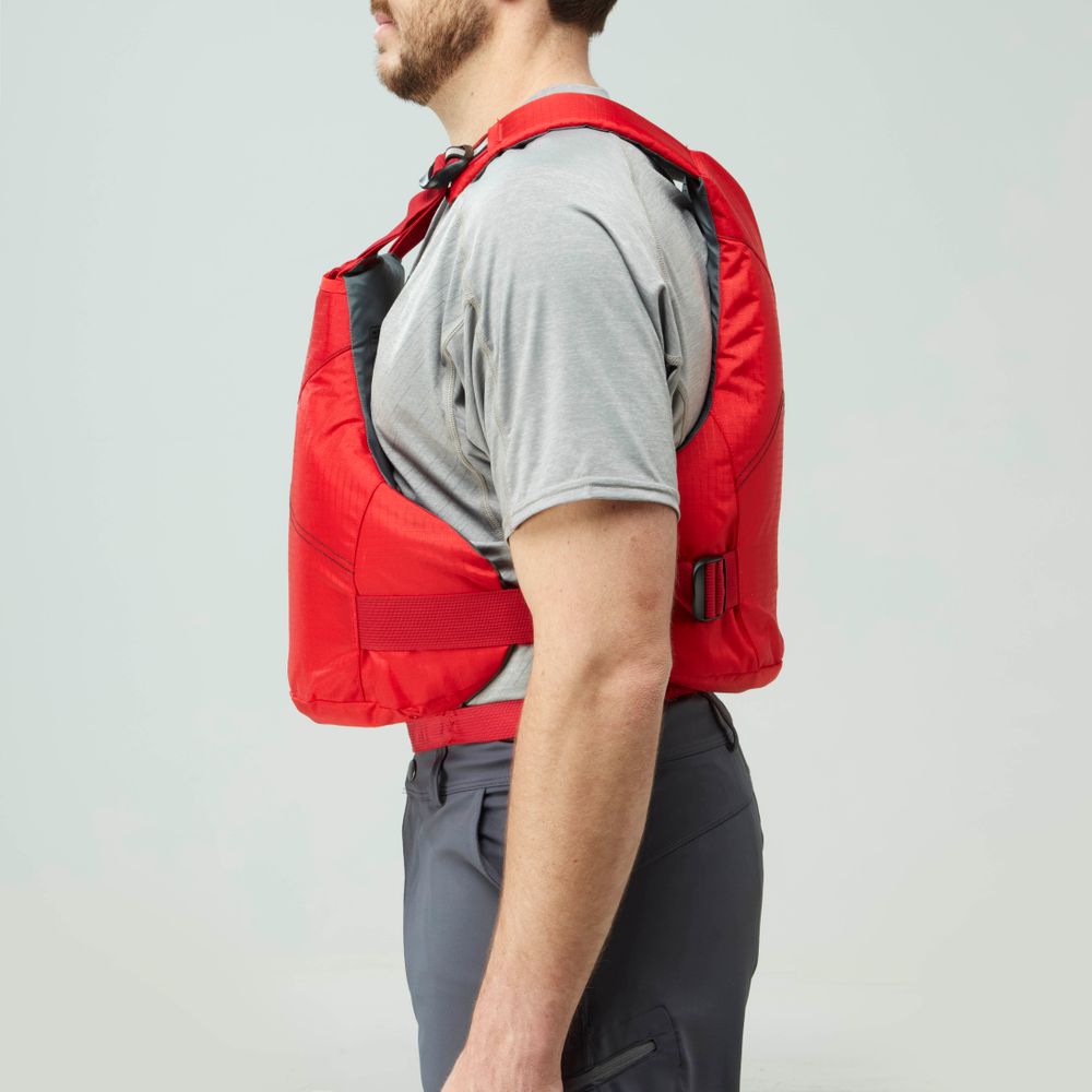 A man in side profile wears the NRS Vapor PFD in red over a grey t-shirt and grey pants, standing against a plain background.