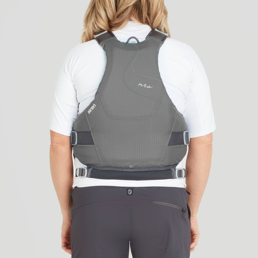 A person wearing the NRS Siren PFD - Women's life jacket, optimized for comfort and adjustable fit, is seen from behind over a white shirt and dark pants against a light gray background.