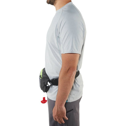 A man in a gray shirt and dark shorts stands in profile, wearing an NRS Zephyr Inflatable PFD with a black waist belt and red pull tab, making it an ideal safety and convenience accessory for standup paddleboarding.