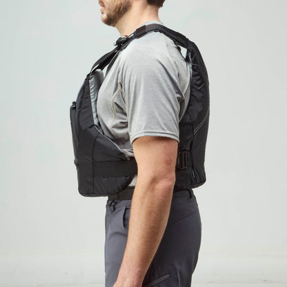 A man in a gray t-shirt and dark pants stands in profile, wearing an NRS Ion PFD—a black Type III life jacket with adjustable straps that meets US Coast Guard Certification standards.