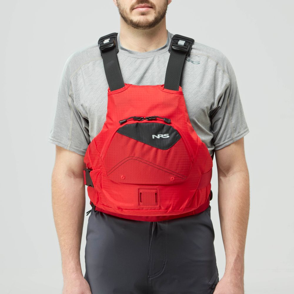 A man faces forward against a plain light background, wearing an NRS Ion PFD life jacket in red over a gray short-sleeve shirt and dark pants.