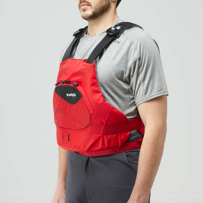 A man in a grey shirt and dark pants models the NRS Ion PFD, a red life jacket with black straps and US Coast Guard Certification, against a plain background.