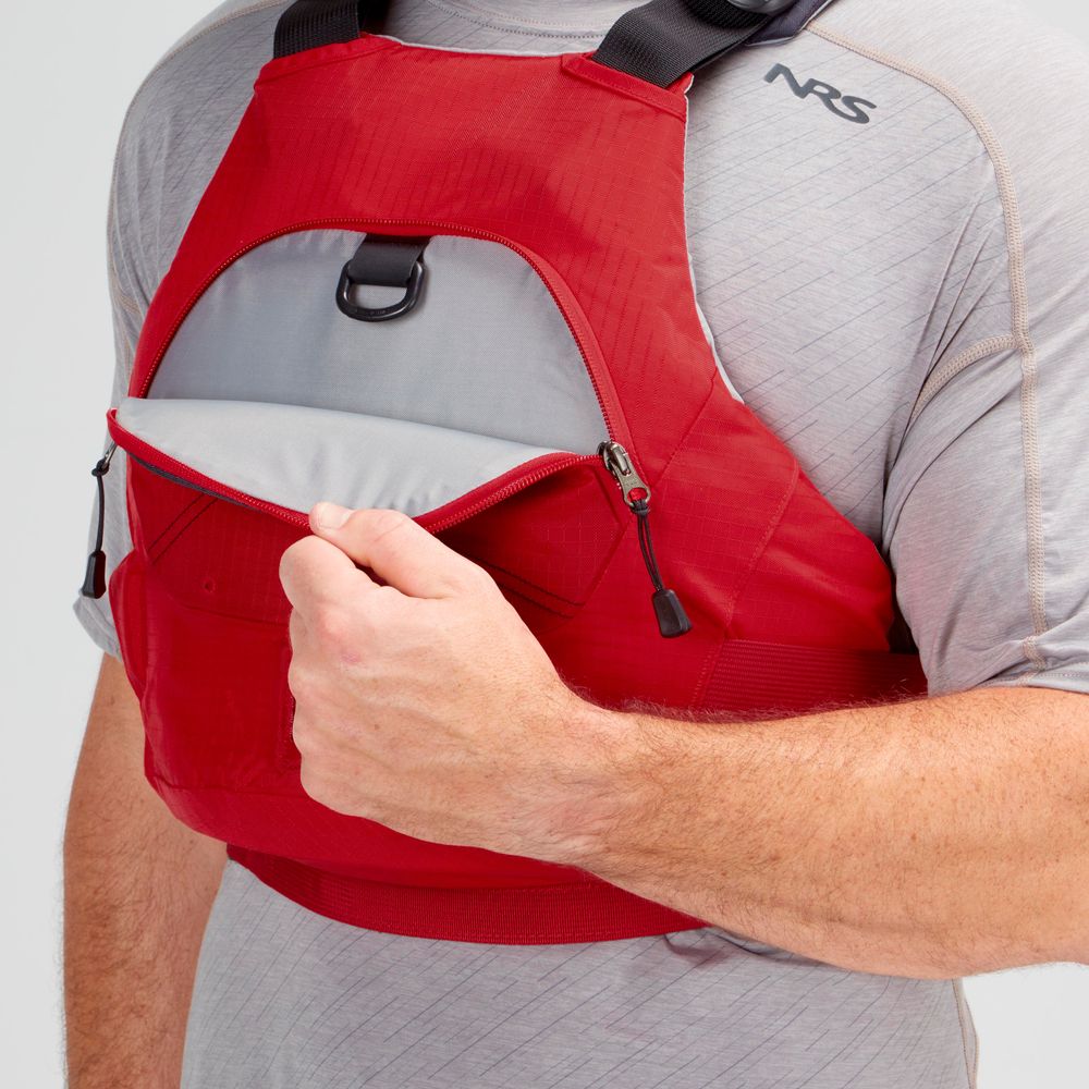 A person opens the front zippered pocket of a red NRS Ion PFD worn over a light gray shirt.