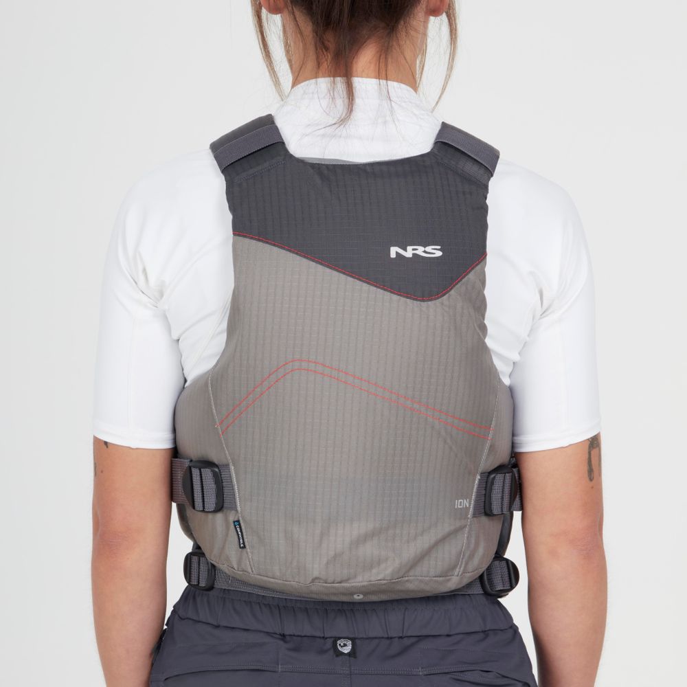 Back view of someone wearing the gray NRS Ion PFD life jacket over a white shirt, showcasing adjustable straps and the logo. This Type III PFD is made with ultra-soft foam for comfort and meets US Coast Guard Certification standards.