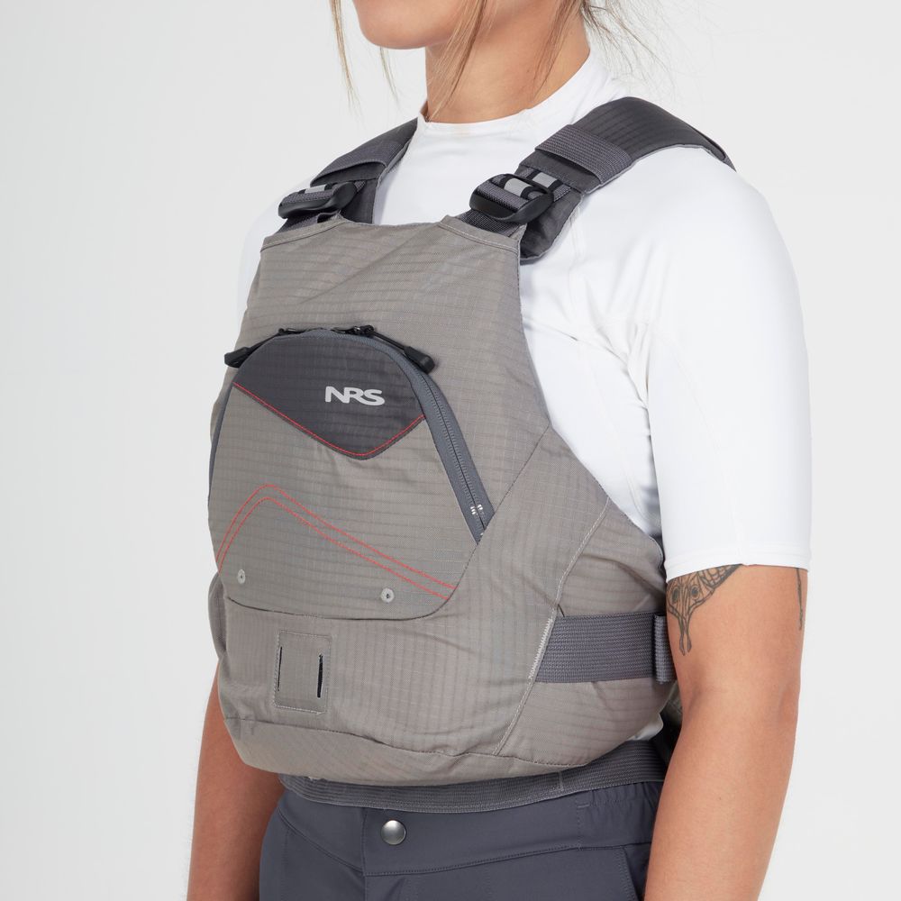 A person wearing an NRS Ion PFD in gray over a white shirt and dark pants is shown from the chest up against a plain background.