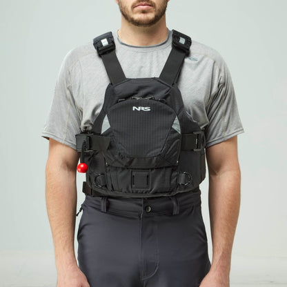 A person in a gray t-shirt and black pants models the NRS Ninja Pro PFD, a black rescue vest with adjustable straps and a front pocket—perfect for whitewater paddlers.
