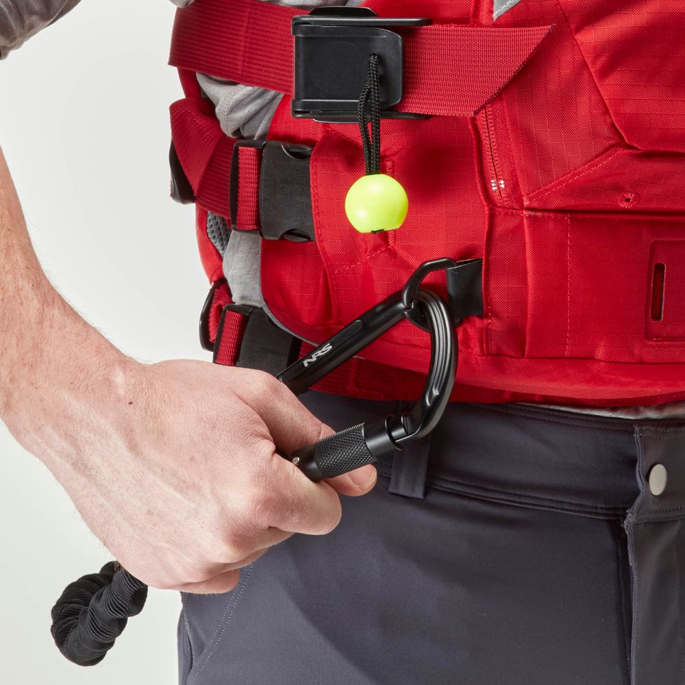 Someone clips a black carabiner to a red NRS Ninja Pro PFD, with a yellow ball on a cord nearby—a trusted setup for whitewater paddlers.