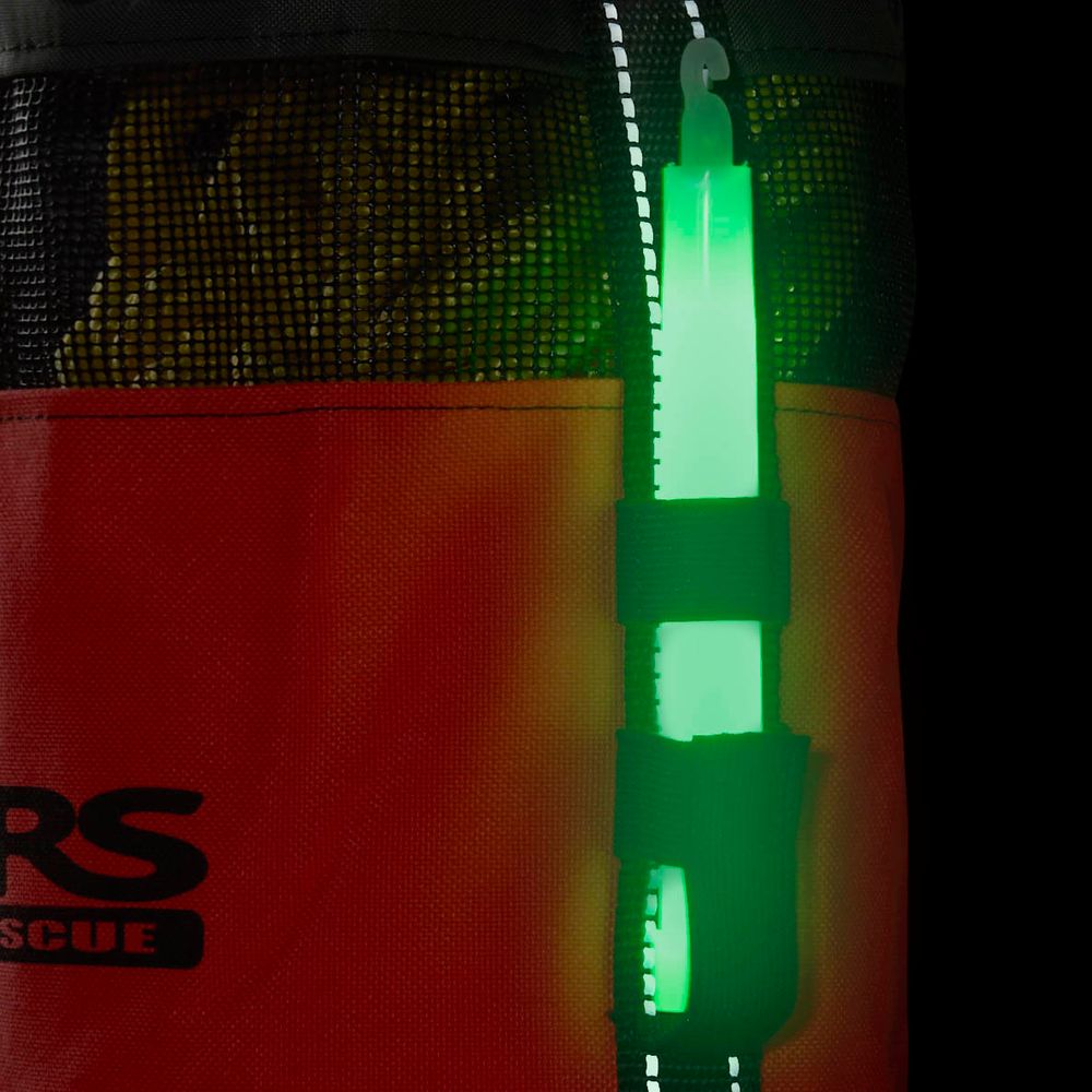 A green glow stick hangs from an orange and black NRS Standard Rescue Throw Bag 75', crafted from durable Cordura nylon, featuring visible netting and a partially obscured logo.