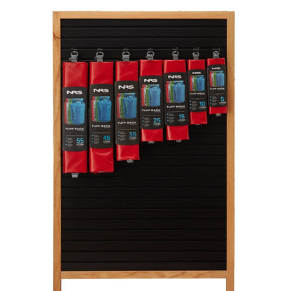 NRS Tuff Sack dry bags, equipped with the StormStrip system, are showcased in multiple sizes and a vibrant red hue, hanging on a wooden slotted board.