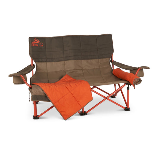 A Kelty Low Loveseat Nest with a blanket on it.