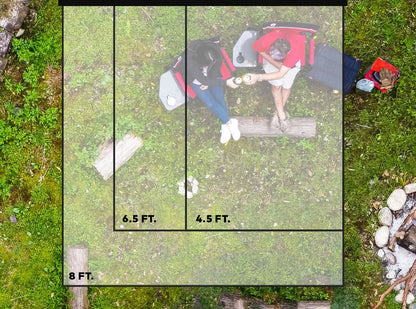 An aerial view of a group of people camping in the woods with the Slim Shady 6.5 by Yakima.