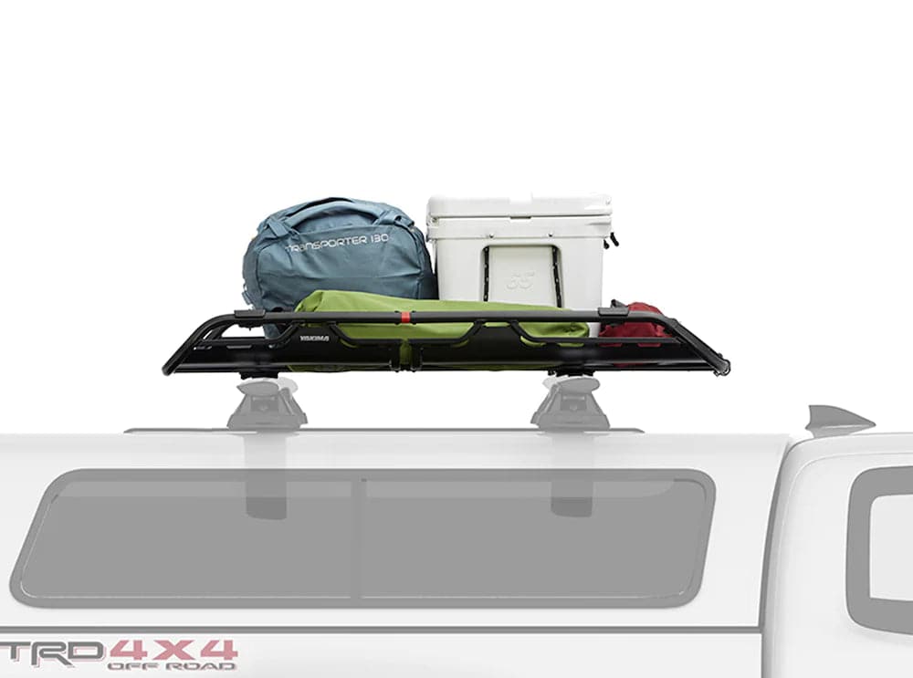 A white truck with a Yakima Offgrid Basket on top of it.